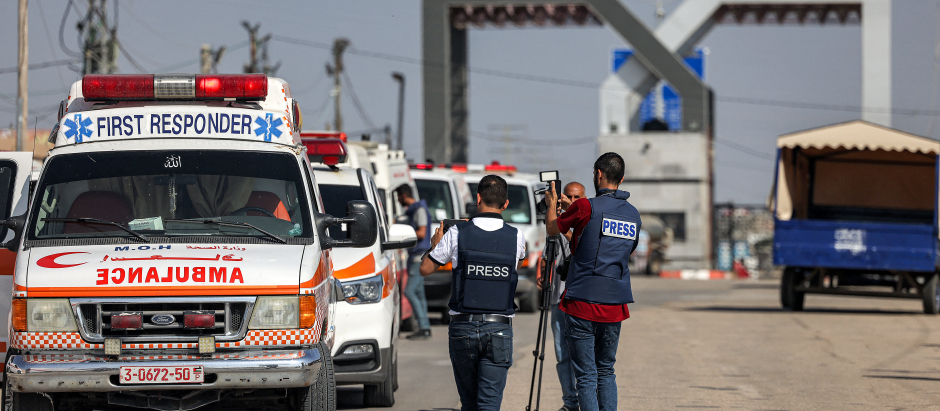 Las ambulancias del Ministerio de Salud palestino cruzan la puerta para entrar en el cruce fronterizo de Rafah, en el sur de Gaza