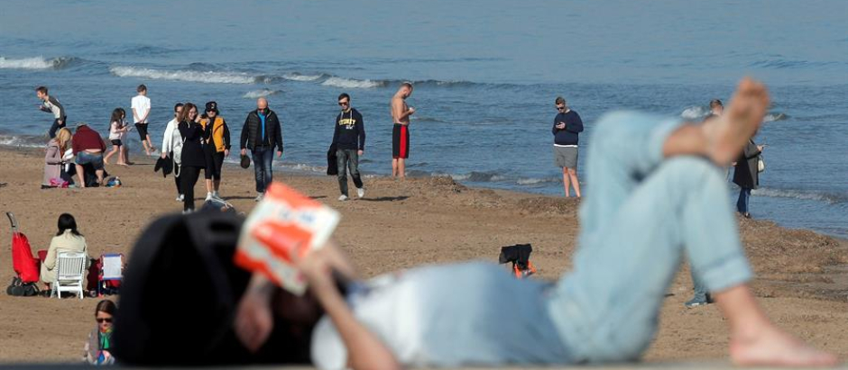 Varias personas disfrutan del buen tiempo en pleno diciembre en la playa de la Malvarrosa, en Valencia