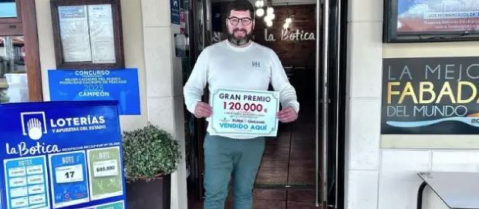 El dueño de La Botica de Lastres, posando con el premio de EuroDreams que vendió en su restaurante