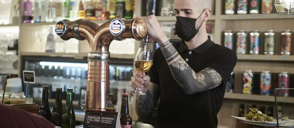 Un camarero sirve una cerveza en el interior de un bar durante la pandemia.