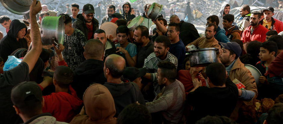 Civiles palestinos esperan su turno para acceder a ayuda humanitaria en Gaza