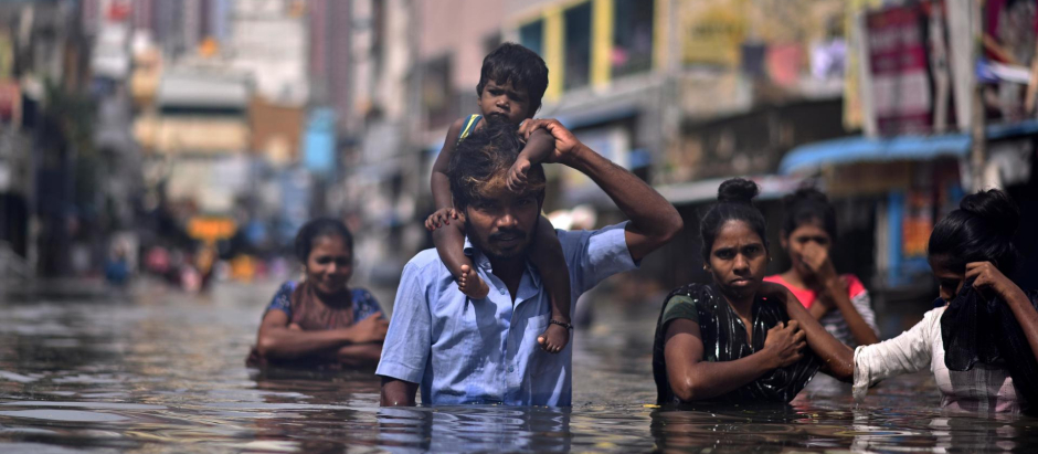 Ciudadanos caminan por una calle inundada después de un fuerte aguacero durante el Ciclón en Chennai, India