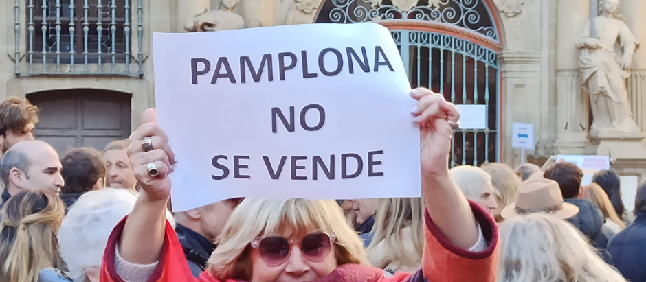 Una mujer sostiene una pancarta en la manifestación: «Pamplona no se vende»