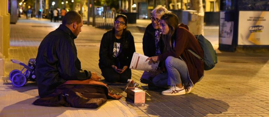 Miembros de la Fundación Arrels atienden a una persona sin hogar en Barcelona