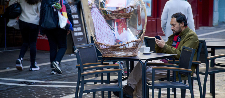 Un hombre consulta su móvil mientras toma un café en Pamplona