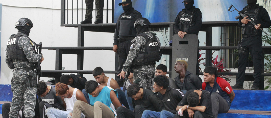 Policías custodian a los detenidos de un grupo armado por la toma temporal de un canal de televisión, en Guayaquil (Ecuador)