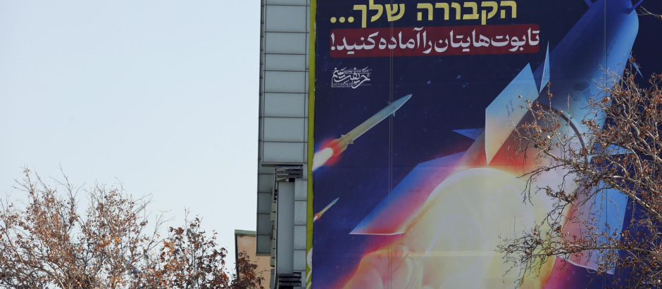 Un cartel que representa misiles iraníes con un mensaje en persa y hebreo que dice: "preparen sus ataúdes", cuelga en un edificio en la plaza Palestina en Teherán, Irán