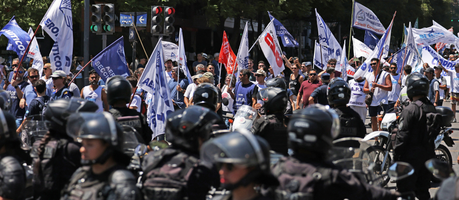 Un grupo de manifestantes argentinos vigilados por la policía antidisturbios en Córdoba, Argentina.
