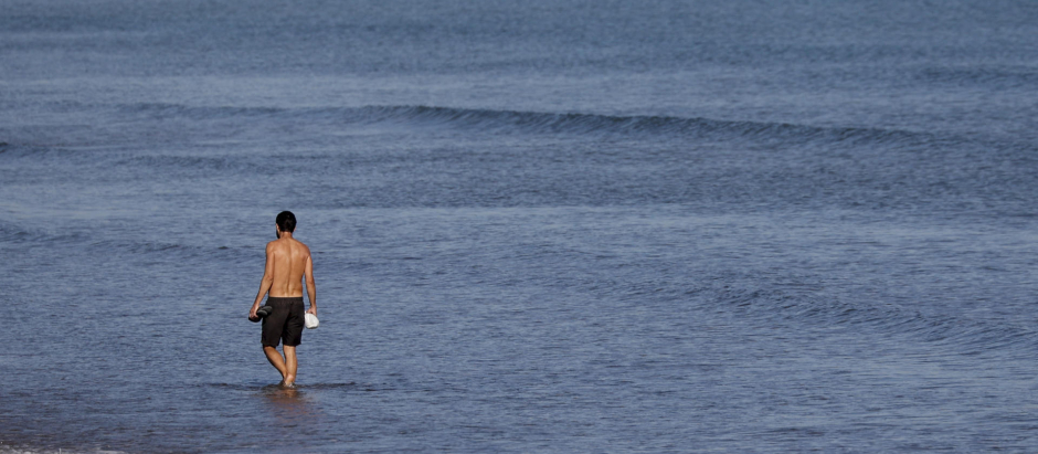 Una persona disfruta del buen tiempo en aguas de la playa de la Malvarrosa