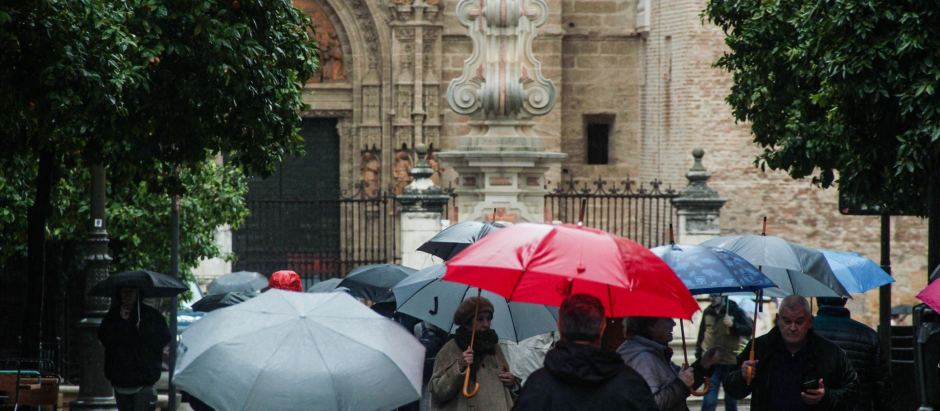 Varias personas se protegen de la lluvia bajo sus paraguas