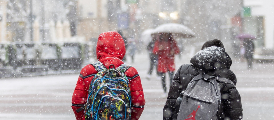 Dos niños caminan mientras nieva en Soria