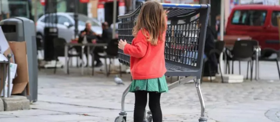 Una niña camina junto a la terraza de un bar en el centro de Madrid