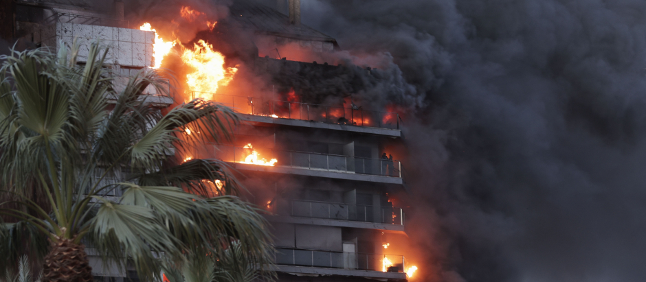 Vista del incendio declarado sobre las cinco y media de esta tarde en un quinto piso de un edificio de viviendas de València que ha afectado totalmente al inmueble y se ha propagado a otro anexo, y los bomberos intentan aún rescatar a vecinos desde los balcones.