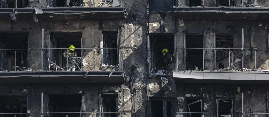 Un bombero inspeccionaba este sábado los restos del edificio incendiado en Valencia