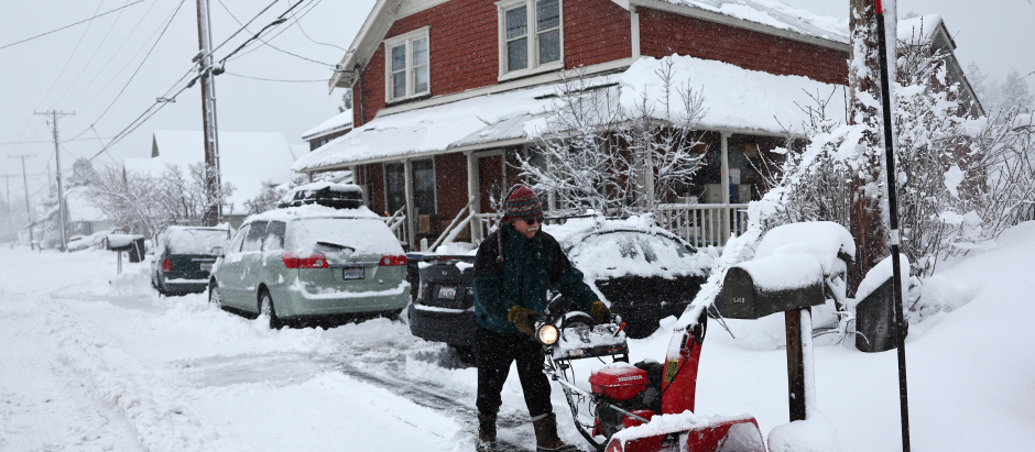 Un hombre limpia su calle de nieve