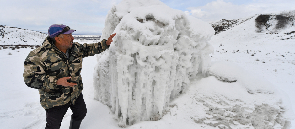 El granjero Erkinbek Kaldanov, de 54 años, inspecciona el glaciar artificial en un desfiladero de montaña cerca del pueblo de Syn-Tash