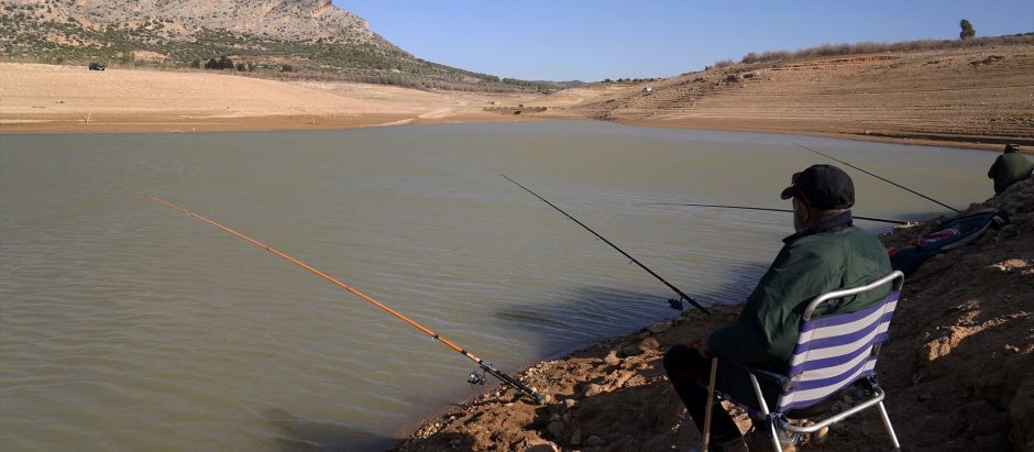 Pescadores intentan pescar en la poca agua que quedan en en el embalse de Guadalteba