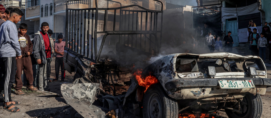 Miembros de la Defensa Civil Palestina apagan un coche en llamas tras el bombardeo israelí en Rafah, en el sur de la Franja de Gaza