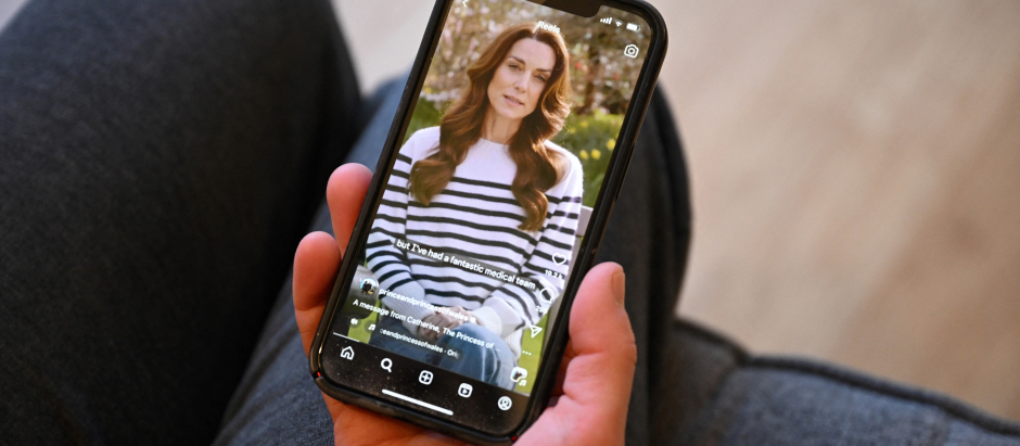 Una mujer mira en su móvil en vídeo en el que Kate Middleton anuncia que tiene cáncer