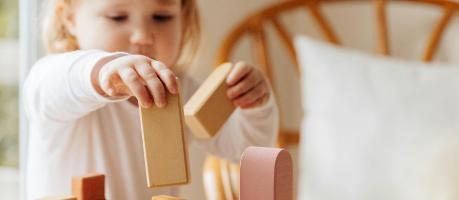 Una niña jugando con bloques de madera
