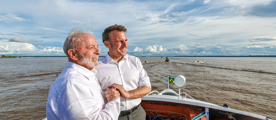 El presidente de Brasil, Luiz Inácio Lula da Silva, le da la mano al presidente de Francia, Emmanuel Macron, a bordo de un barco en la bahía de Guajara, en Belem, Brasil