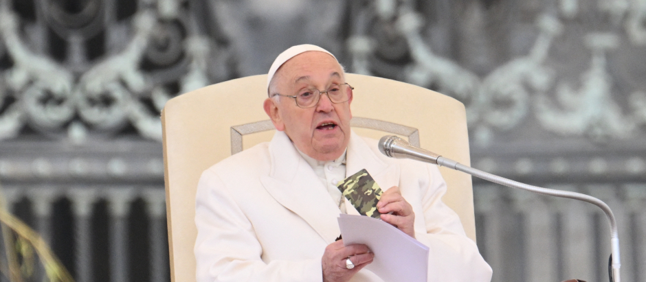 Pope Francis holds a small new Testament from a 23 year old soldier which died in Ukraine during his weekly general audience in St.Peter's square at the Vatican on April 3, 2024. (Photo by Alberto PIZZOLI / AFP)