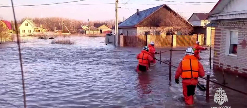 Rescatistas caminando por una calle inundada en la ciudad de Orsk, región de Orenburg