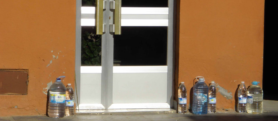 Garrafas y botellas de agua en una puerta