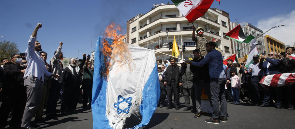Iraníes queman una bandera israelí durante una manifestación que conmemora el día de Al Quds en Teherán, Irán