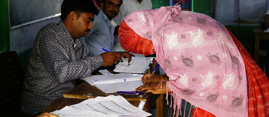 Una mujer se registra para emitir su voto en un colegio electoral durante la primera fase de la votación para las elecciones generales de la India