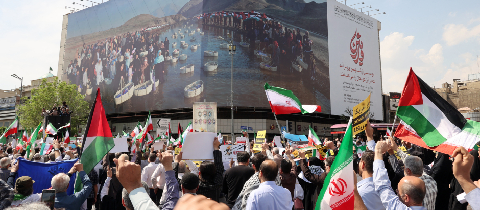 Iraníes ondean las banderas de Palestina e Irán después de la oración del mediodía del viernes en Teherán