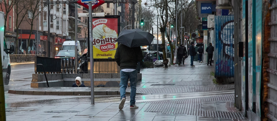 Un hombre se protege de la lluvia con un paraguas