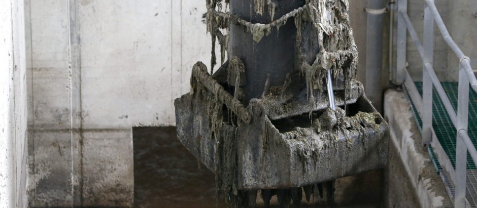 Una pinza mecánica de una depuradora extrae toallitas desechables de las aguas residuales