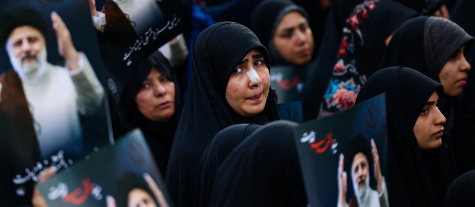 Mujeres iraníes participan en los funerales por Raisí con retratos del presidente fallecido