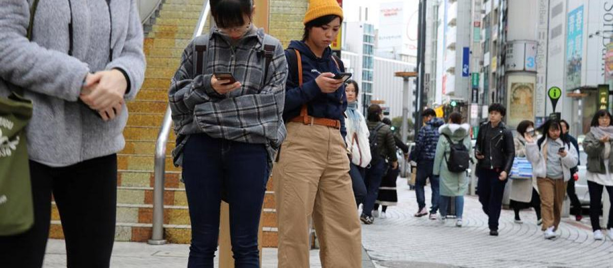 Jóvenes utilizan el móvil en las calles