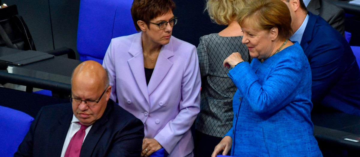 La canciller alemana Angela Merkel (derecha) habla con el ministro de Economía alemán Peter Altmaier (izquierda)