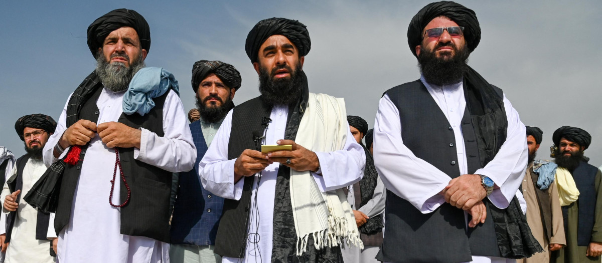 El portavoz de los talibanes, Zabihullah Mujahid (C), habla con los medios de comunicación en el aeropuerto de Kabul
