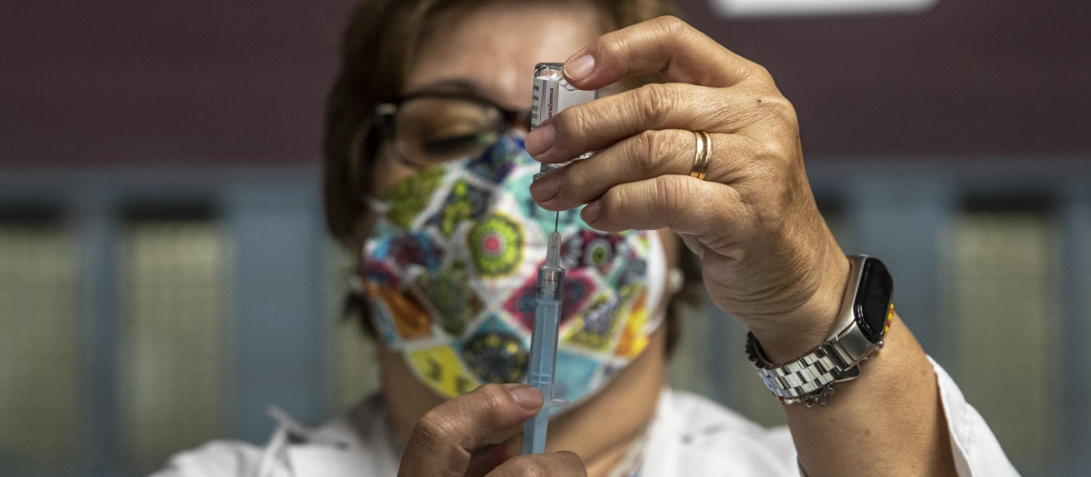 Una sanitaria prepara una vacuna.