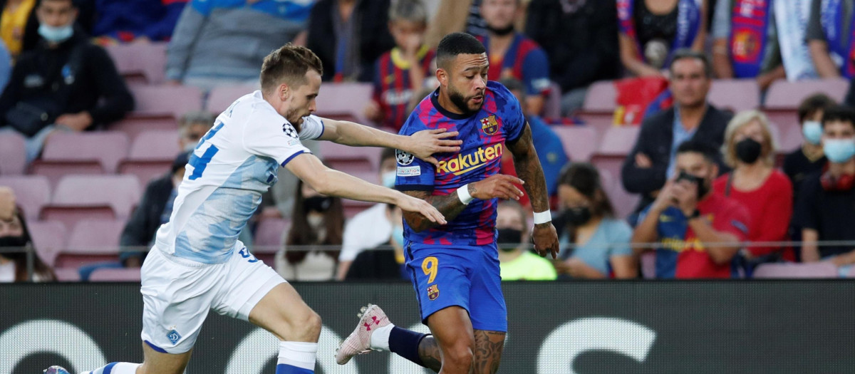 El delantero holandés del FC Barcelona Memphis Depay (d) disputa el balón ante Tomasz Kedziora (i), defensa polaco del Dinamo de Kiev