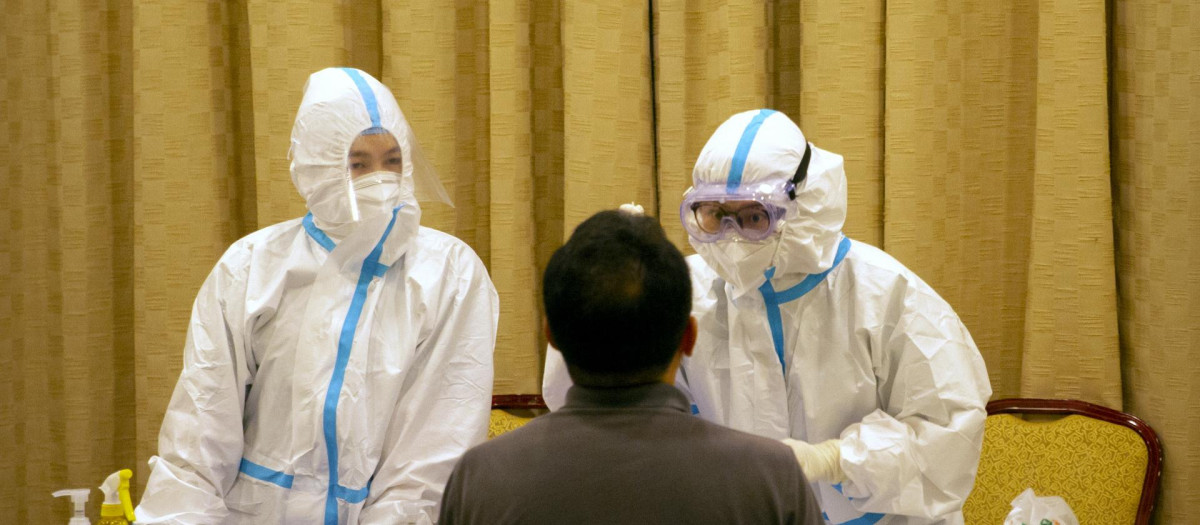 Trabajadores chinos trabajando para la detención de coronavirus