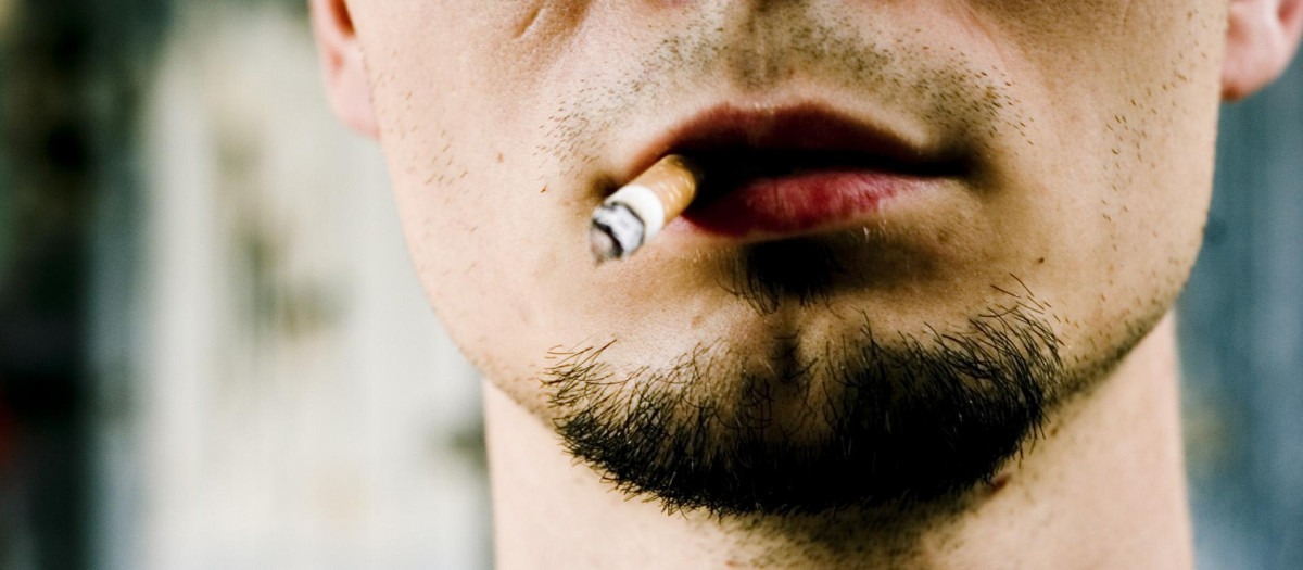 Un hombre fuma un cigarrillo