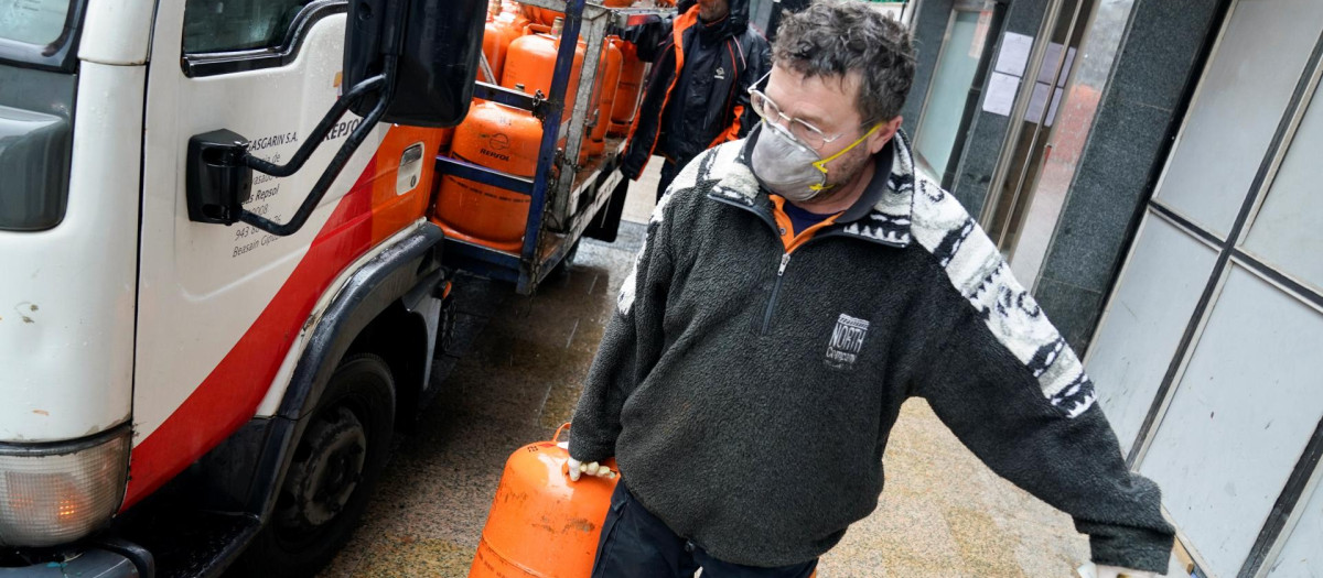 Un operario transporta una bombona de butano