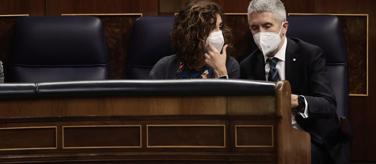La ministra de Hacienda, María Jesús Montero, y el ministro del Interior, Fernando Grande-Marlaska, conversan en la sesión plenaria en el Congreso