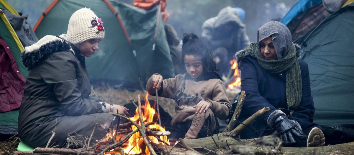 Migrantes de Oriente Medio y otros lugares se calientan en el incendio que se avecina en la frontera entre Bielorrusia y Polonia cerca de Grodno