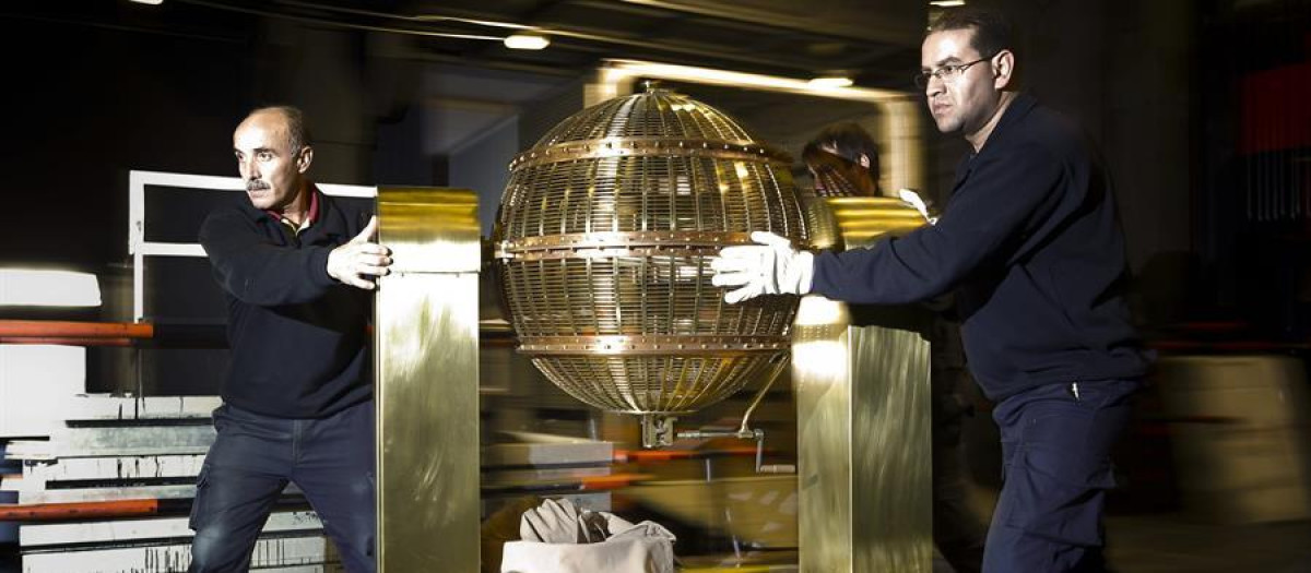 Dos operarios preparan el bombo de la Lotería de Navidad, fotografía de archivo