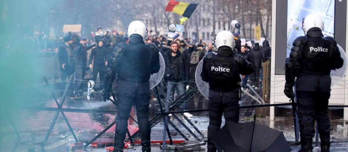 Varias personas protestan frente a la policía belga después de que el Ejecutivo de Bruselas haya endurecido las medidas para frenar el aumento de casos de coronavirus y haya implantado la obligatoriedad de las vacunas.