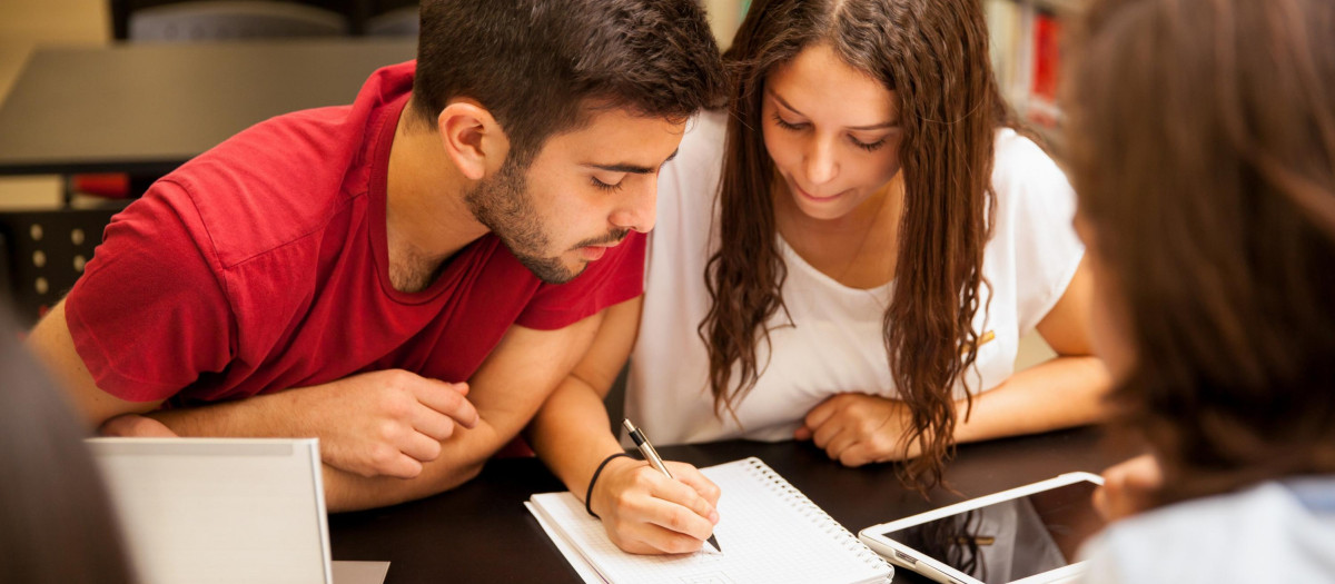 Grupo de estudiantes estudiando juntos en la biblioteca.