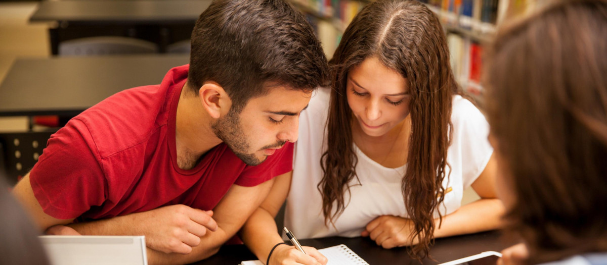 Grupo de estudiantes estudiando juntos en la biblioteca.