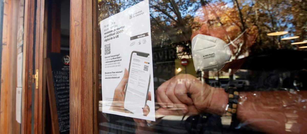 El propietario de un bar coloca un cartel advirtiendo del certificado en Barcelona