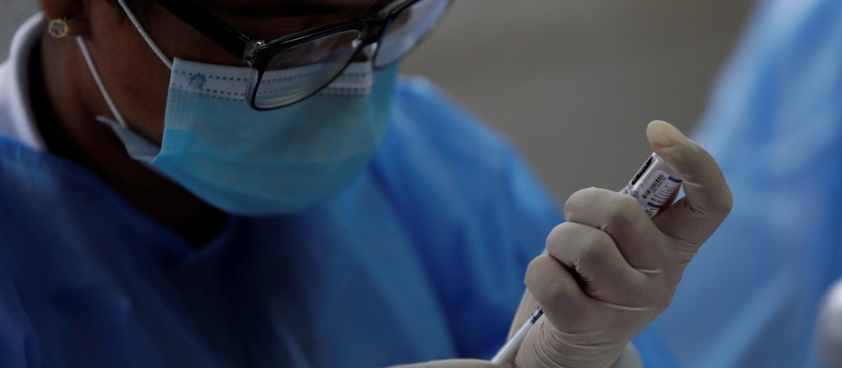 Una médico prepara una dosis de vacuna de Pfizer